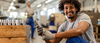 African American worker checking quality of manufactured steel parts