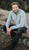 Jeff Shainline sitting on a log on a hill in the mountains outside Boulder