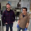 Sam Oberdick and Gary Zabow pose for a picture, standing together with lab equipment in the background.