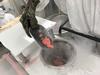 Pieces of salmon are being fed from a metal holder into the icy opening of a milling machine. 