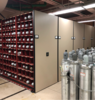 Photography of gas cylinder storage facility with cylinders stored horizontally in movable cabinets.