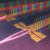 Illustration shows tiny columns of light in different colors standing vertically along circuits on a chip. 