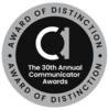 Circle badge. Silver exterior ring with writing at top and bottom: Award of Distinction. Black interior. Lowercase letter A. Words: The 30th Annual Communicator Awards