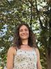 Esther Baumann poses outdoors with trees in the background.