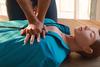 A person performs chest compressions on a CPR practice mannequin. 