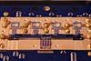 Circuit board with various square chips and gold screws. Small letters in the center say: NIST True Bq.
