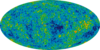 Oval-shaped colorized image shows spots of red and yellow over a mostly green and blue background.