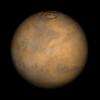 Color-enhanced photo of Mars shows the planet with patches of orange and brown. 