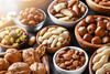  Mixed nuts in wooden bowls on black stone table.  