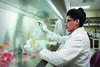 Photo of a person in a lab coat working in a lab. Photo courtesy of the University of Delaware. Photographer: Evan Krape