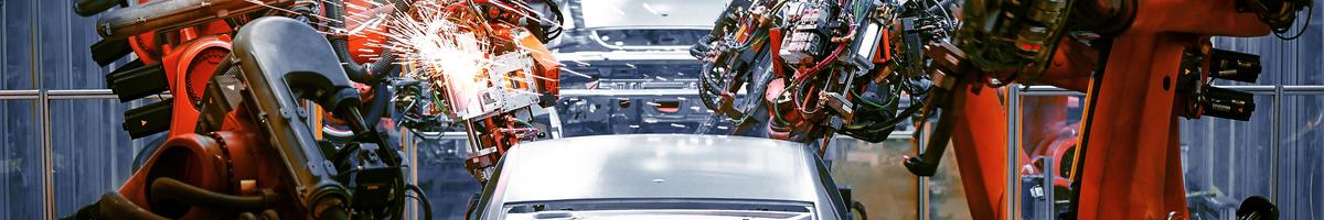 Cars on an assembly line with robotic arms doing work on them. Credit: Shutterstock/Jenson